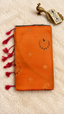 Orange soft silk saree with copper zari paisley butta and pink tassels